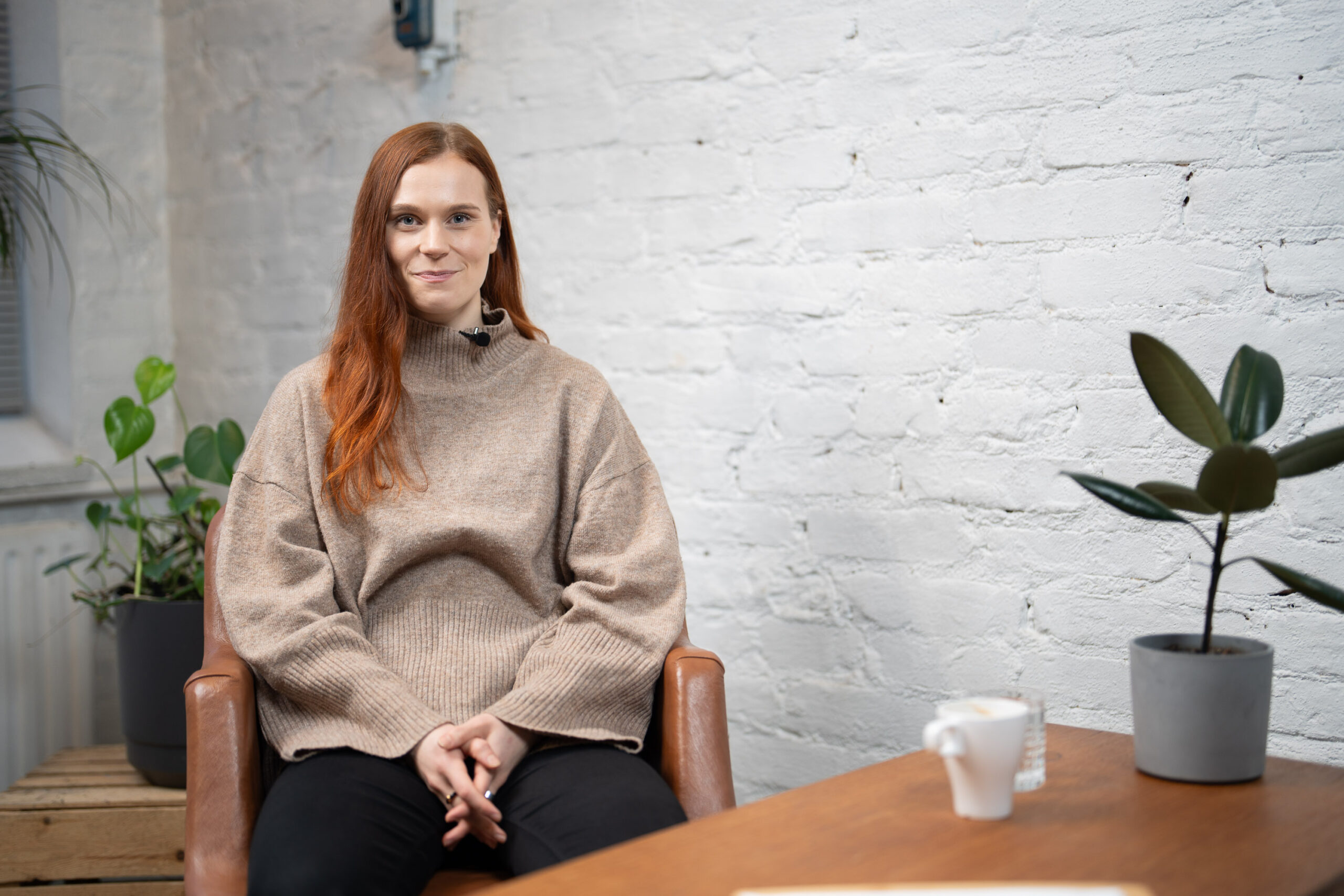 Selkon selkokielen asiantuntija Marianna istuu studiossa ja hymyilee kameralle.