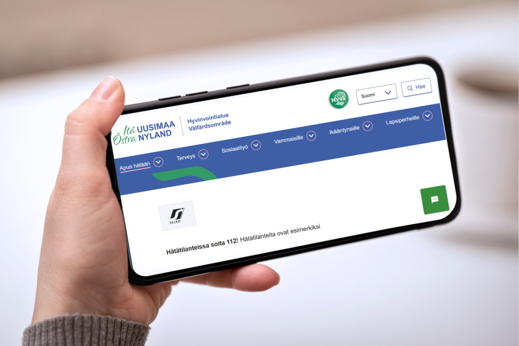 Lähikuva vaaka-asennosta olevasta puhelimesta, jolla on auki Itä-Uudenmaan hyvinvointialueen verkkosivut. Sivulla näkyy Selkotunnuksen S-kirjaimen muotoinen logo.
