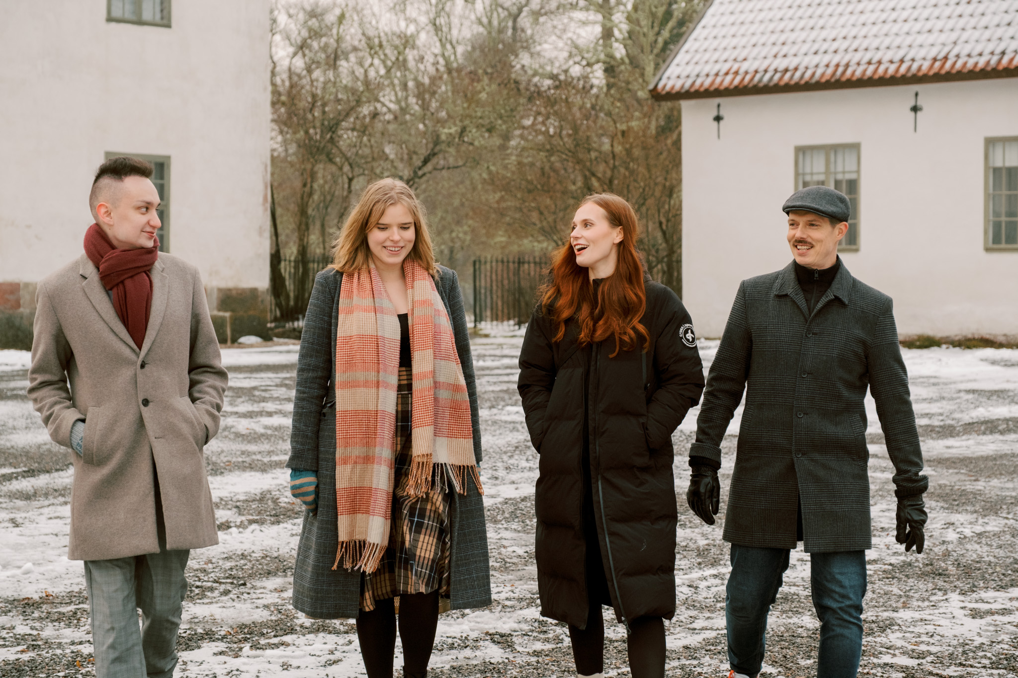 Selkon neljä asiantuntijaa kävelemässä kartanon pihalla ja juttelemassa keskenään.